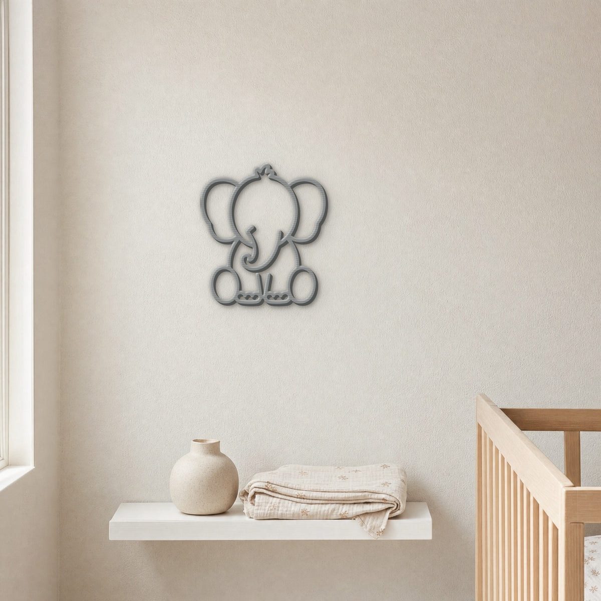 Grey 3D printed elephant wall art above a nursery shelf