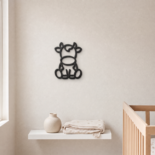 Black 3D printed cow wall art above a nursery shelf